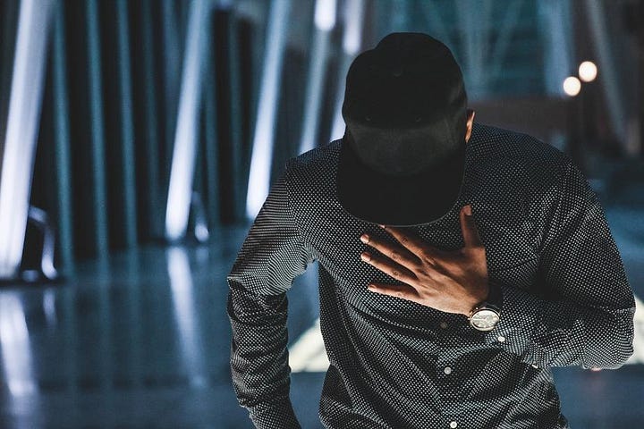 Man walking with hat down over his face.