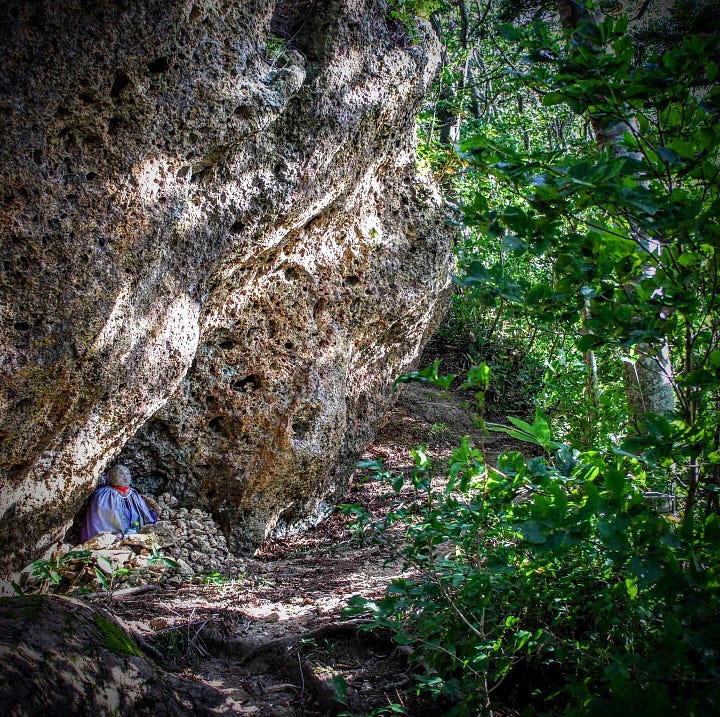 A Jizo statue tucked under a huge rock near the summit of Mt. Kyogakura in Sakata City, Yamagata Prefecture, Tohoku region of Japan.