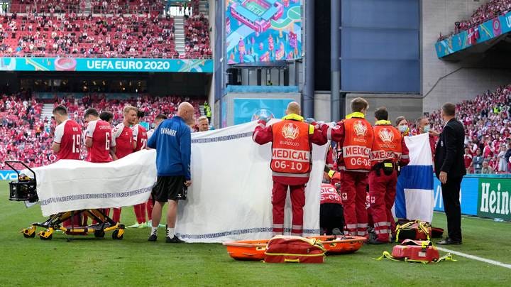 Christian Eriksen is covered by medical staff after collapsing on the field