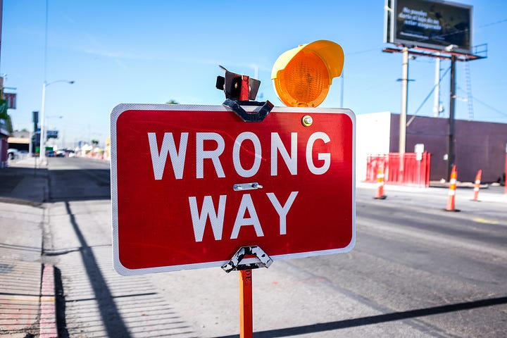 A big read road sign saying “wrong way”.