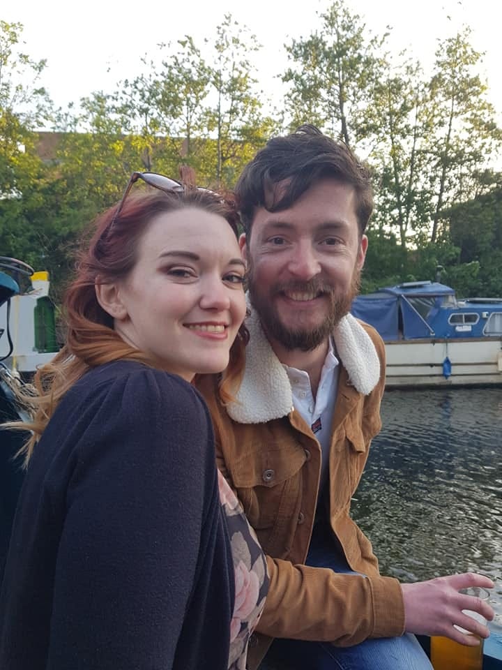 Alex Innes with his girlfriend Lucy Green by a river with a boat in the background
