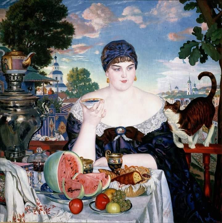A lush, plump young Russian woman of the 19th century, drinking tea as she sits down to a rich outdoor feast. Her tabby cat is rubbing against her, wanting to be rewarded for flattery with food.