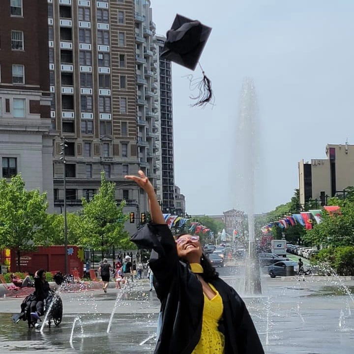 A girl throwing her grad cap infront of Philly Art Museum, a place she loves.