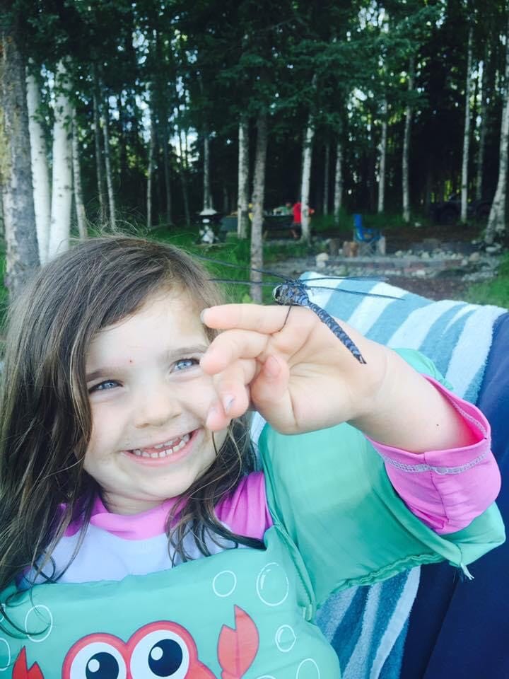 girl holding a dragonfly