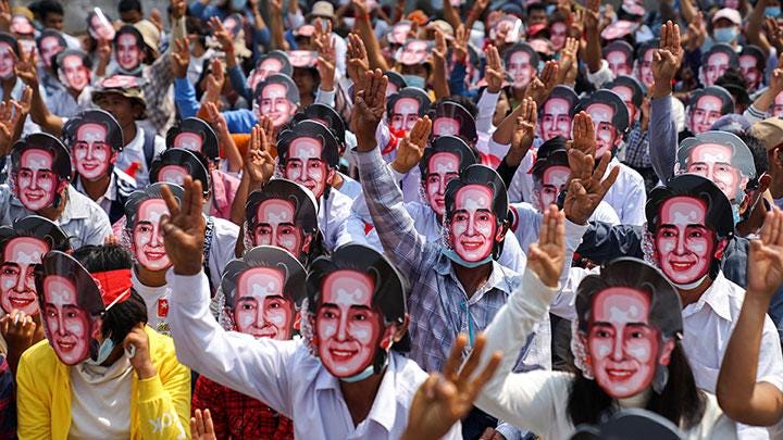 Pengunjuk rasa anti-kudeta menggunakan topeng Aung San Suu Kyi.