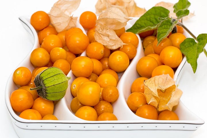 Photo of a large white platter of tangerines, decorated with scat leaves.