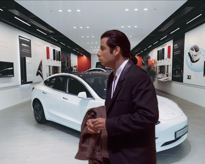 john travolta stares around at an empty Tesla store
