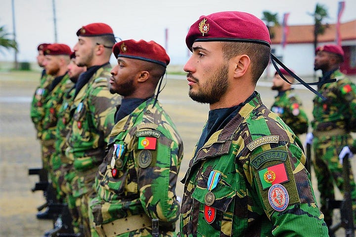 Portuguese military commandos are lining up for a mission. They are wearing the Portuguese commandos red barret and are in battle suit.