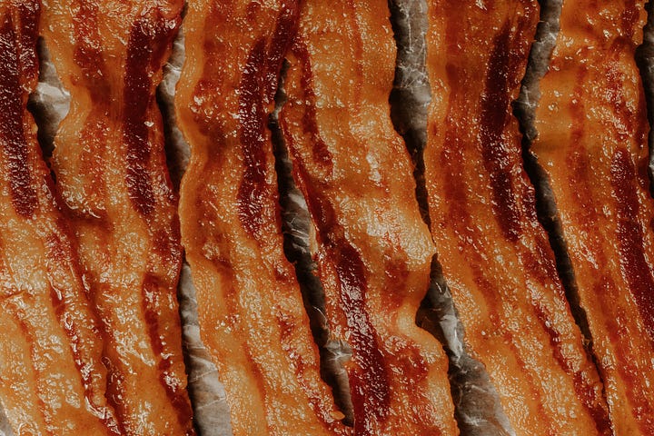 Photo of six slices of cooked bacon.