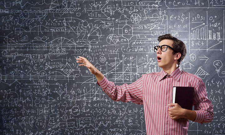 A slightly overwhelmed-looking young man at a blackboard full of equations.