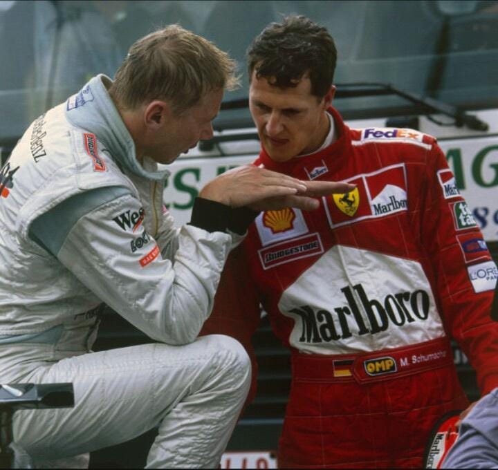 Mika Häkkinen explaining something to Michael Schumacher