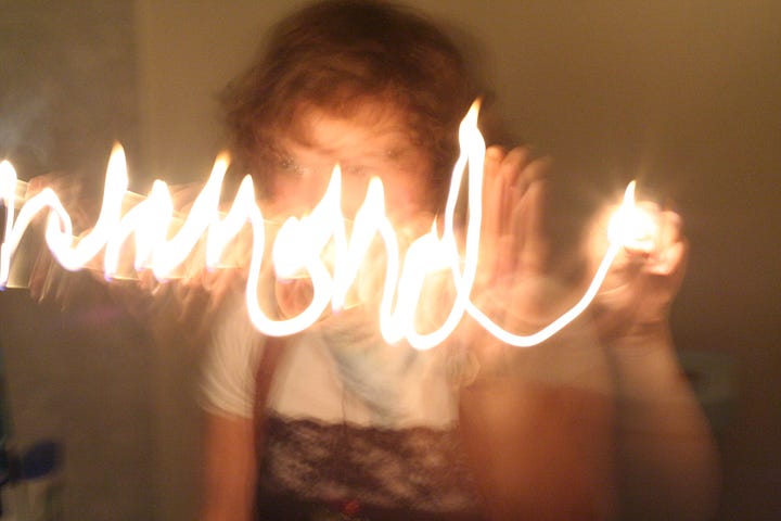 A blurry long-exposure photo of a person writing with light.