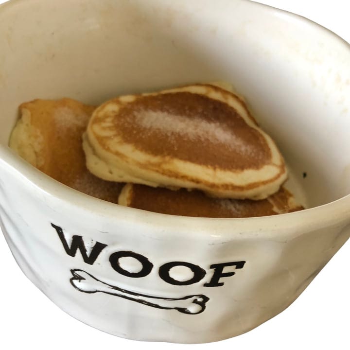 Pancakes in a dog bowl with “woof” written on the side