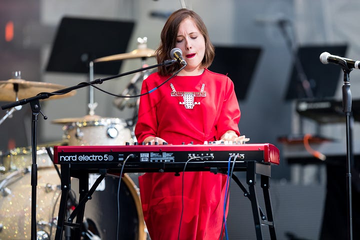 Young woman in red dress at an electronic keyboard