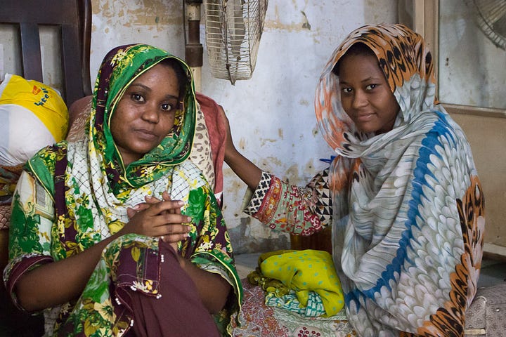 Hina Yaqoob and her cousin sitting in their home.