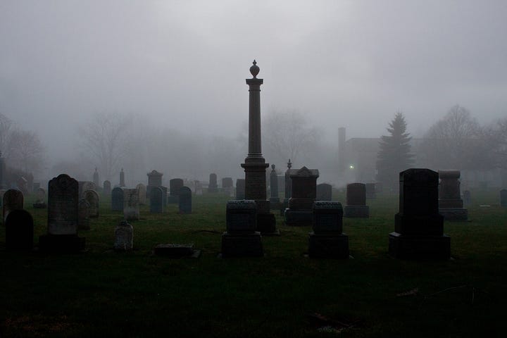 A cemetery in winter with fog rolling in