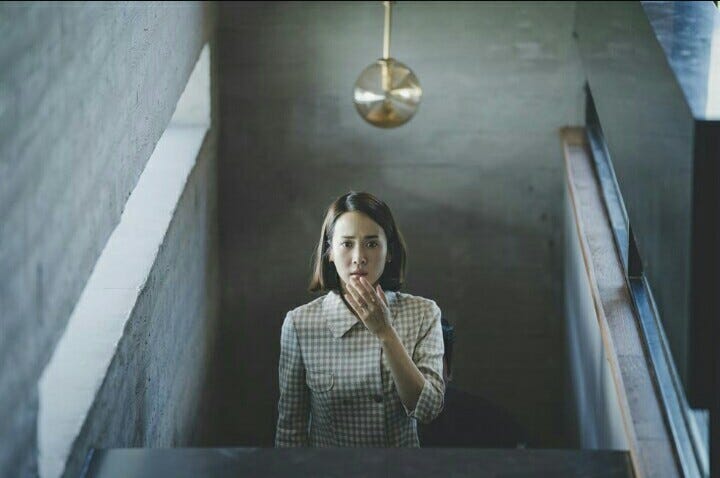 A still of a shocked female character from the movie ‘Parasite’ directed by Bong Joon-ho and released in 2019.