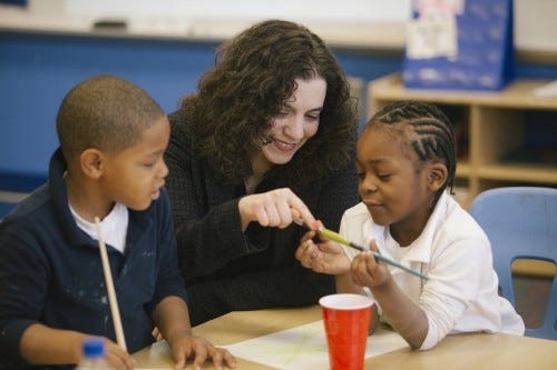 Progressive Arts Alliance Executive Director Santina Protopapa visits with kindergarteners during a recent workshop at Mound STEM School.