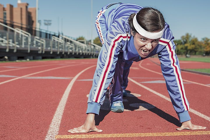 A female athlete takes a running stance