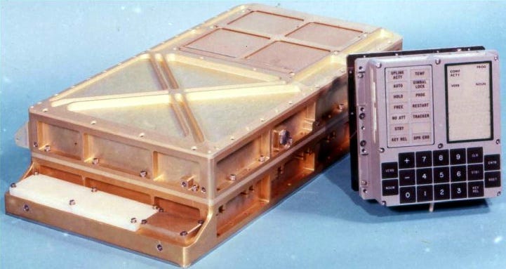 Computador Apolo Guidance Computer, formato retangular com cor de cobre e com um terminal com botões do lado
