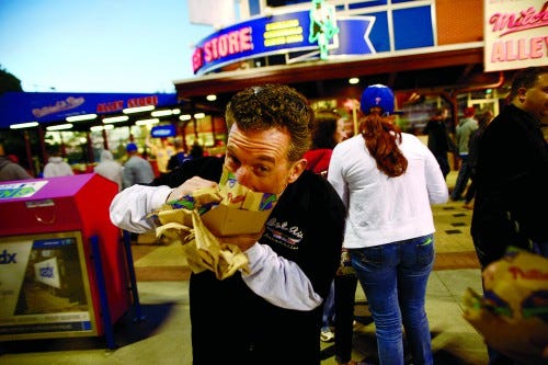 Andy Ungaro chows down during a Phillies game. Some additions to the food stands at Citizens Bank Park have the crowd buzzing. At left, the Gluten Free stand offers the specialty meats and veggies.