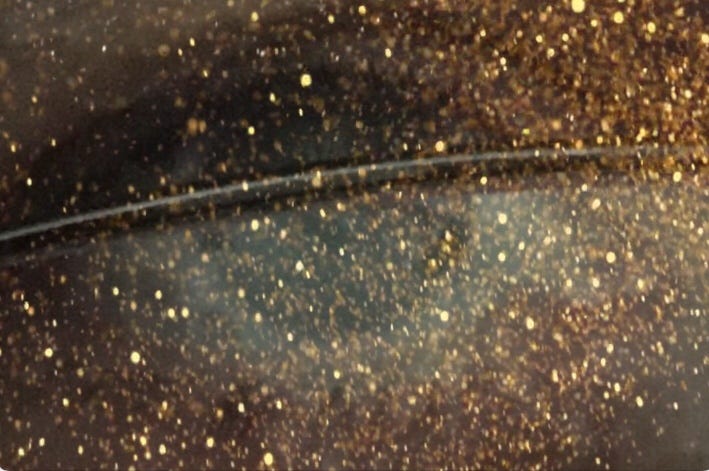 Human eye behind the rim of eyeglasses faded to an overlay of stars.