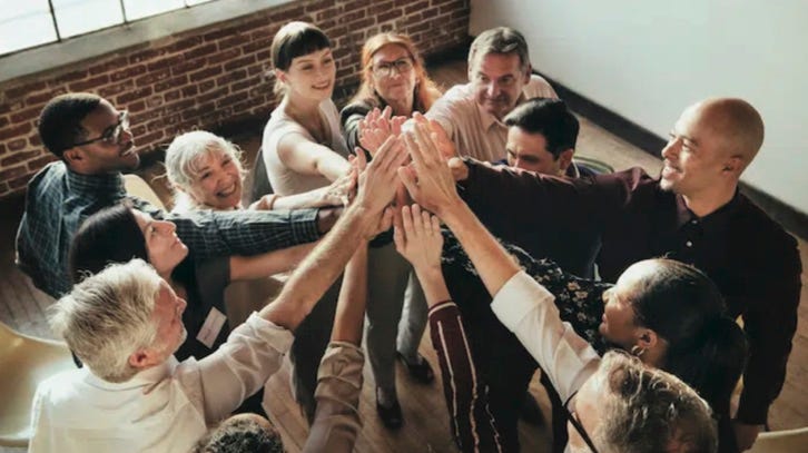 photo of a group of office workers high fiving