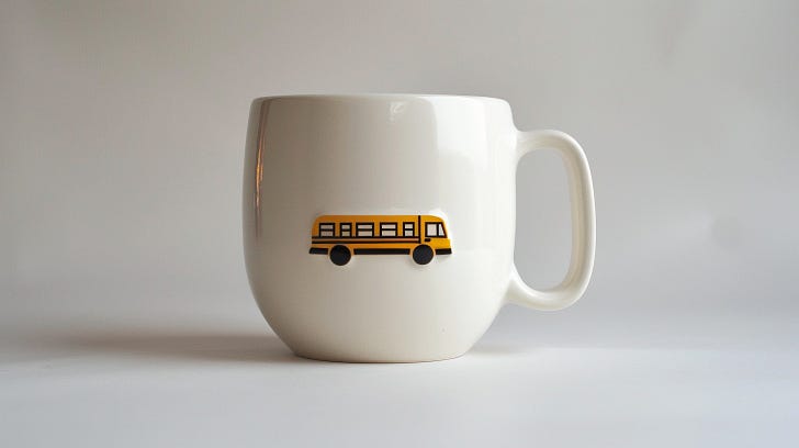 A white coffee mug with a picture of a bus on the side