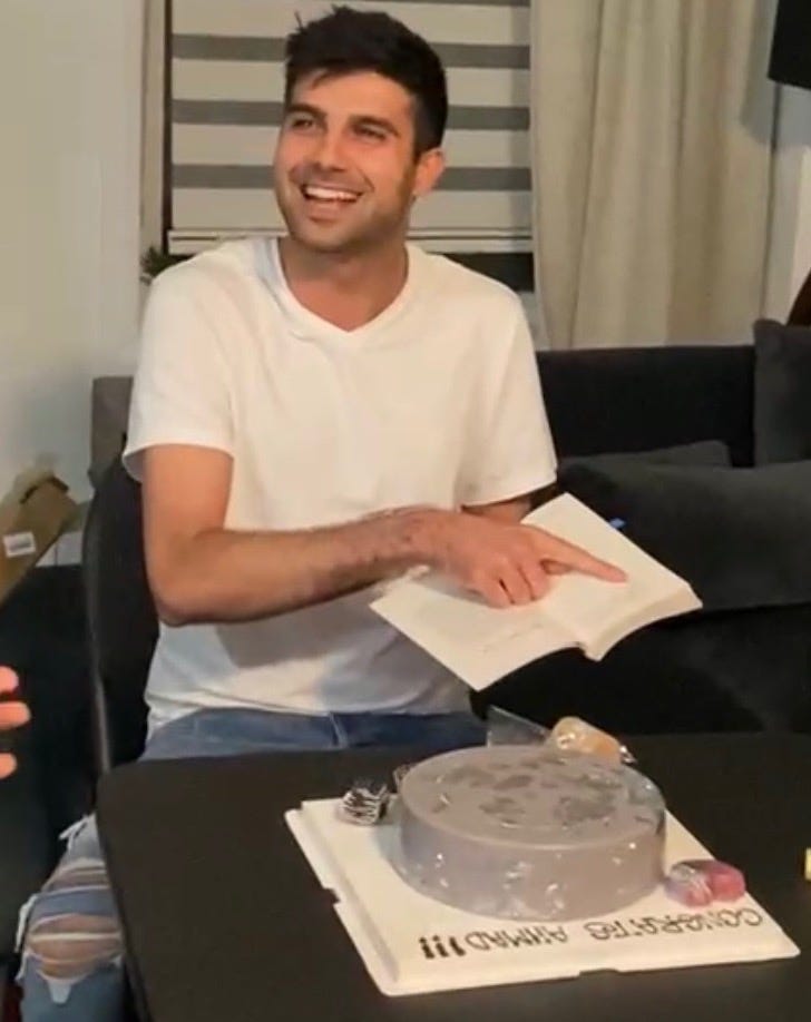 Man smiling reading the last page of a book.
