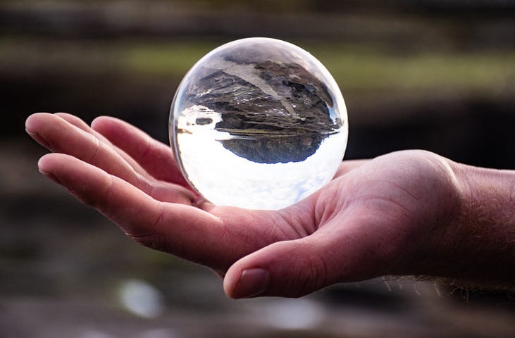 person’s hand holding a crystal ball