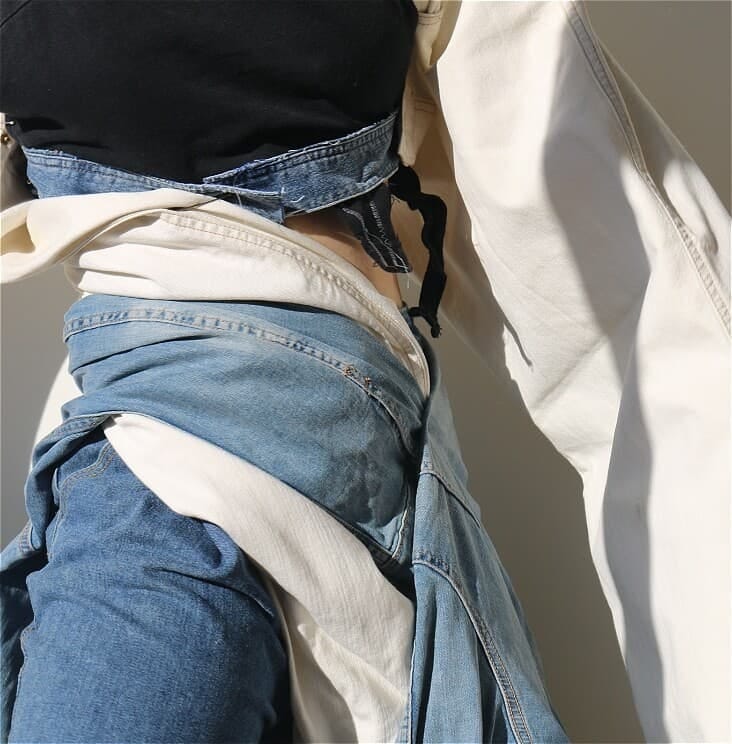 A close-up image of two people wearing mismatched denim in blue and white.