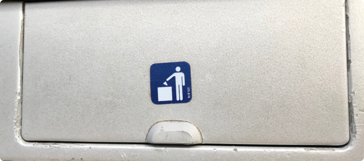 A trash bin and icon indicating its use on the train.