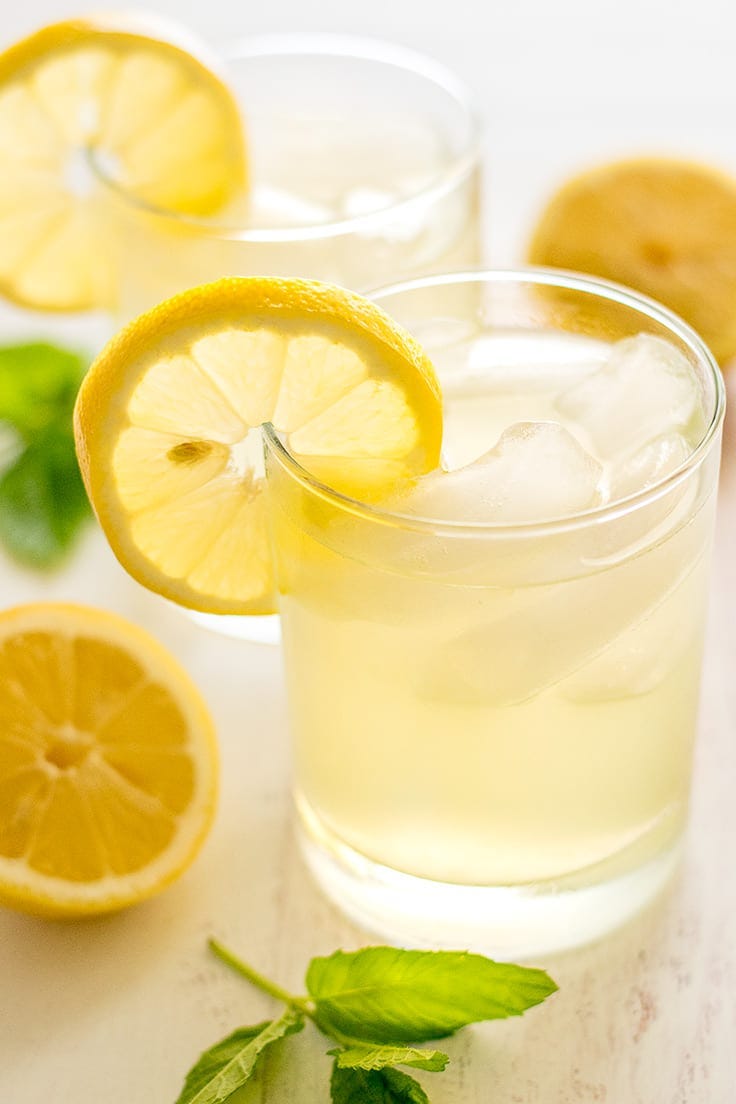 Glass of still lemonade with slice of lemon.