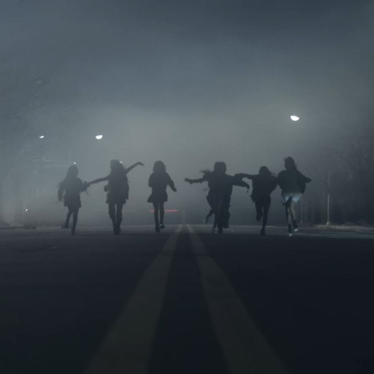 6 young teenagers on a road seemingly running through fog at night