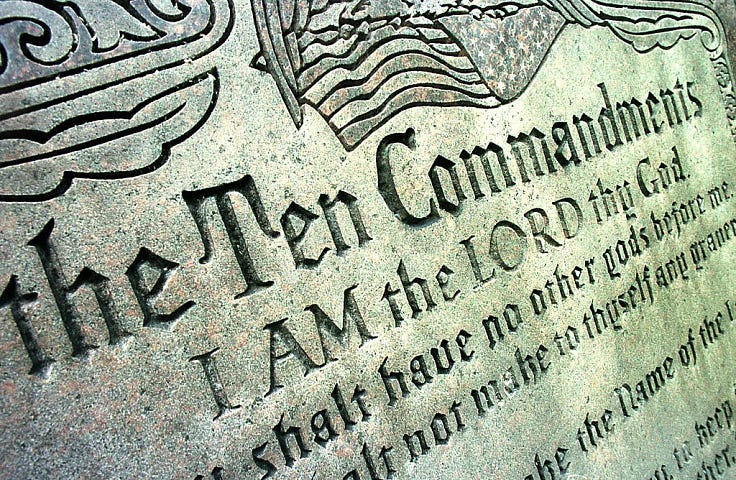 A close up photo of the Ten Commandments inscribed in stone. It reads The Ten Commandments. I AM the LORD thy GOD.