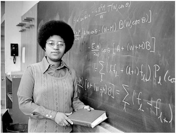 Dr. Shirley Jackson in 1973 at Massachusetts Institute of Technology. She is standing at a chalkboard with mathematical equations on the board, holding a textbook.