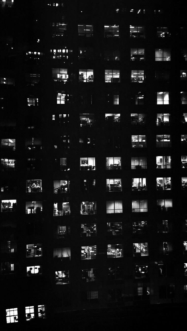 An image of lit-up rooms in an Apartment building, shows that everyone has their own lives to live.