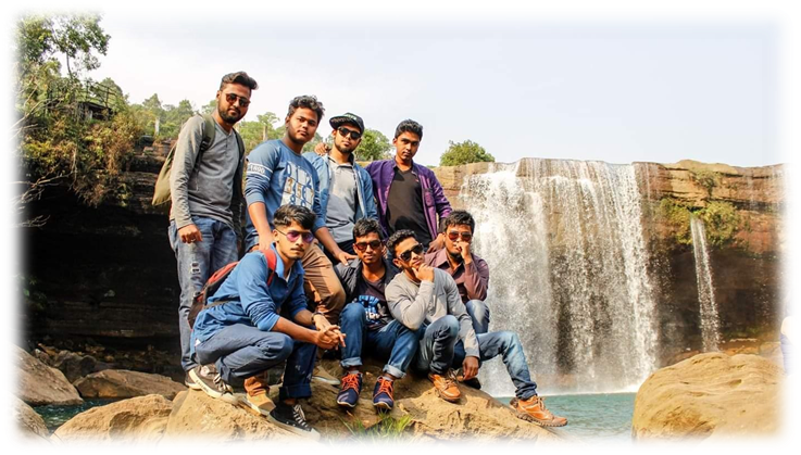 The author and his friends posing in front of a waterfall.