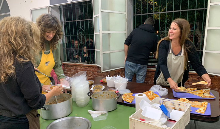 Cuatro voluntarios de la Parroquia sirviendo comida a personas con escasos recursos económicos.