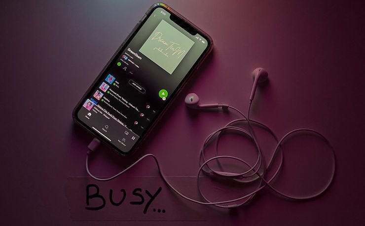 Spotify is open on a phone and headphones