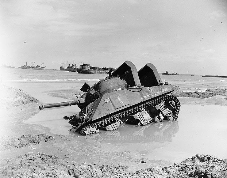 A tank sits stuck in a large puddle in a field.