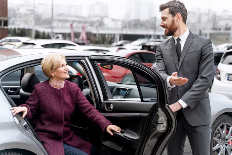 Taxi driver opening car for for female passenger