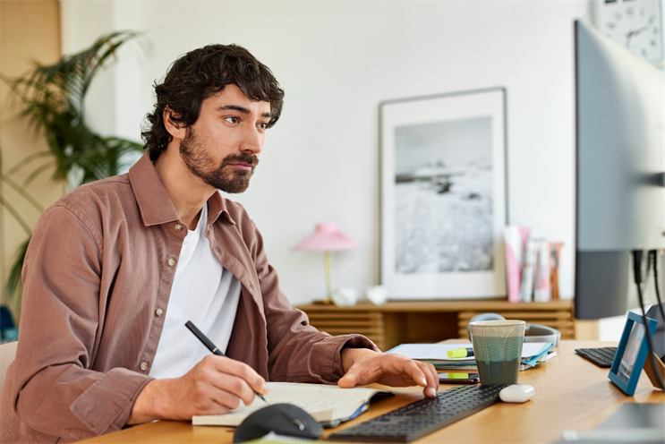 Freelancer/Consultant man working intently at an organized office desk.