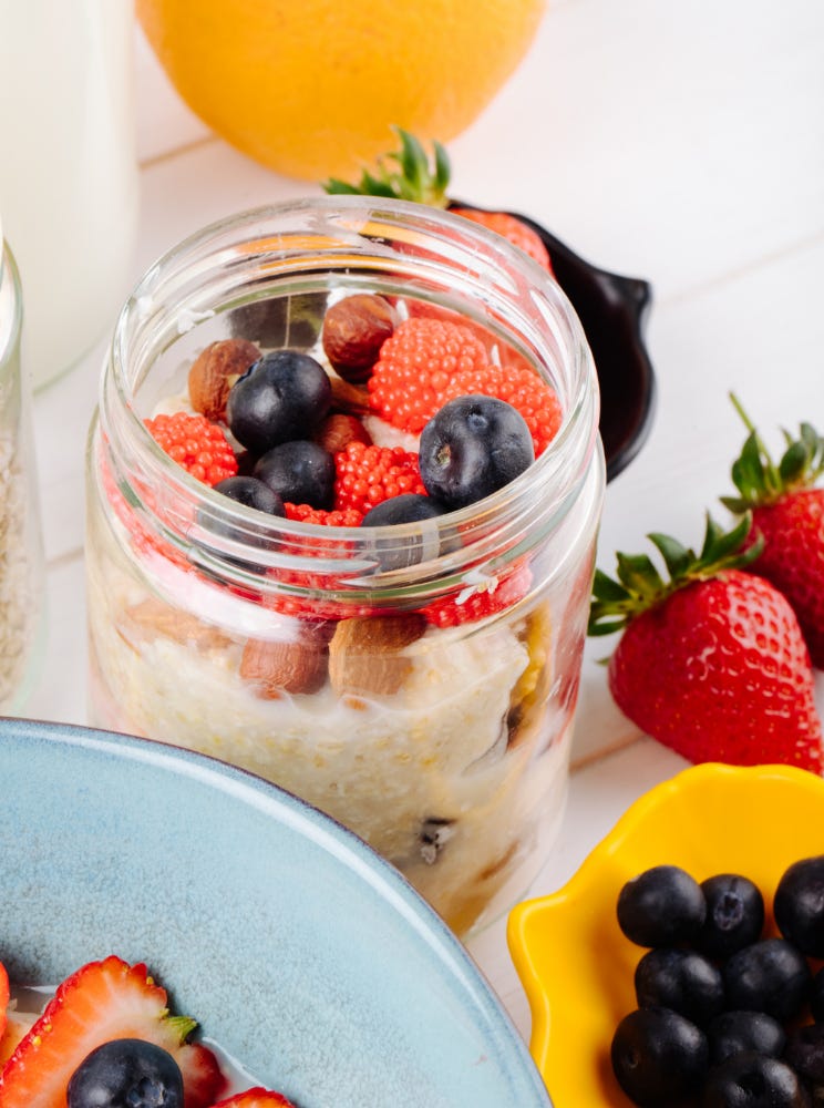 Side-view of a jar containing overnight oats with fruit toppings