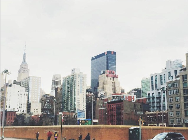 New York City buildings against a gray sky.