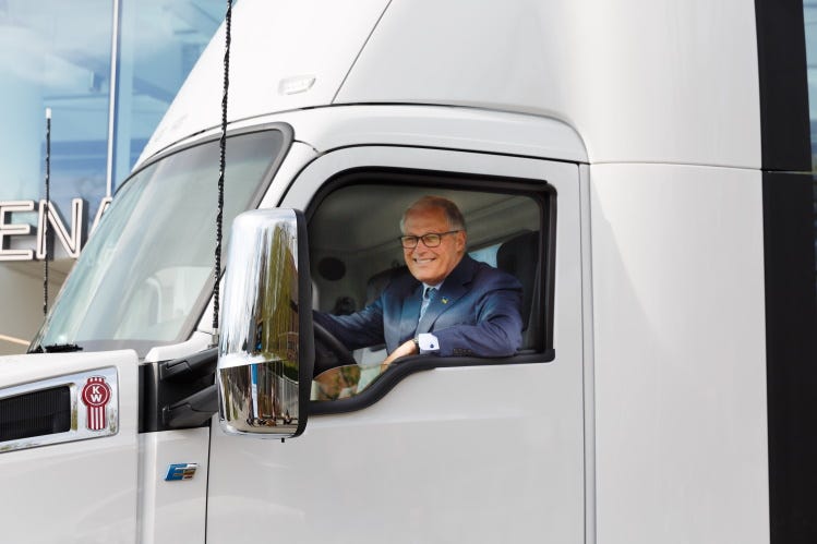 Gov. Jay Inslee sits in the cabin of a Kenworth electric semi truck assembled in Renton, Washington.