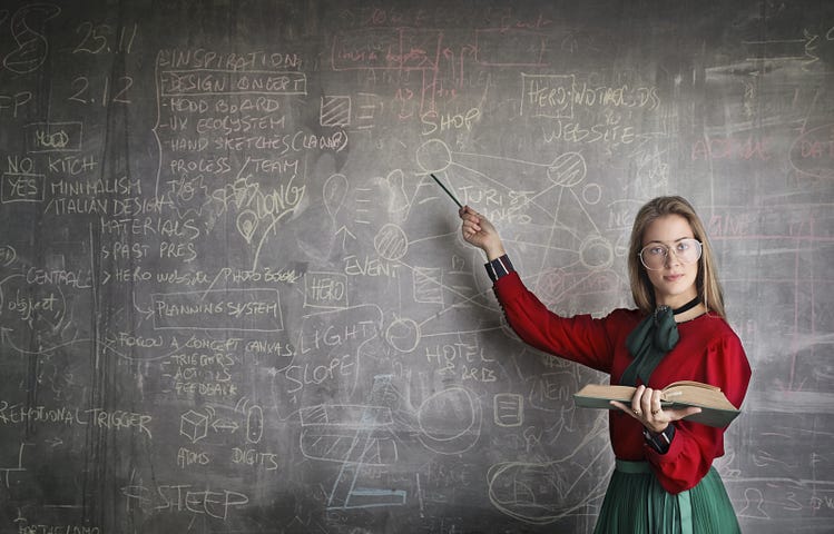 Strict teacher in red holding a stack of books and a pointer, points at a chalkboard covered in math problems