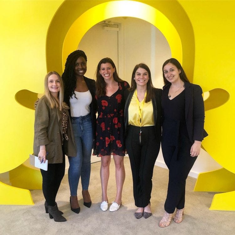 A group of women stand inside a Snapchat logo.
