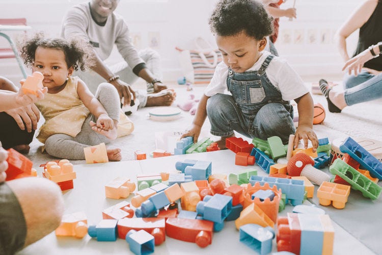 Children playing with legos on the floor.