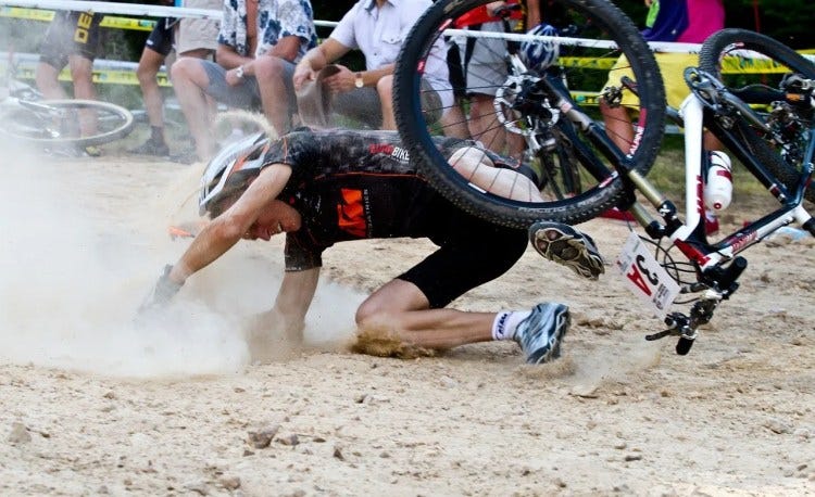 Image by Natalia Gałuszka from Pixabay. During a bike race, a man falls from the bike and into the dirt.